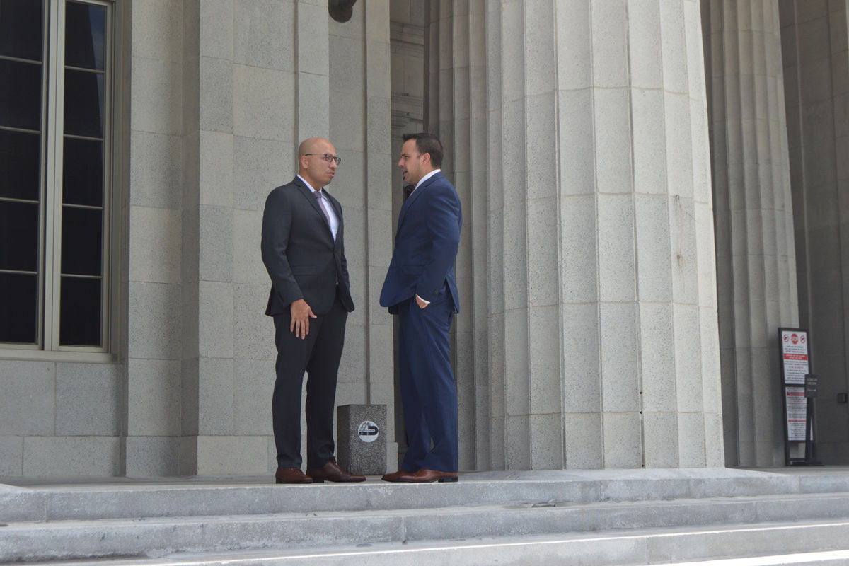 Pedro A. Balderramos speaking with a colleague on the courthouse steps